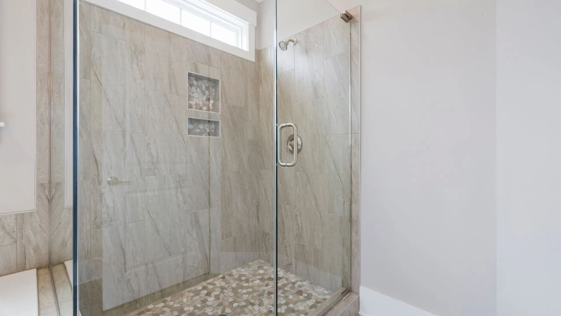 Frameless shower door installation with stone tile